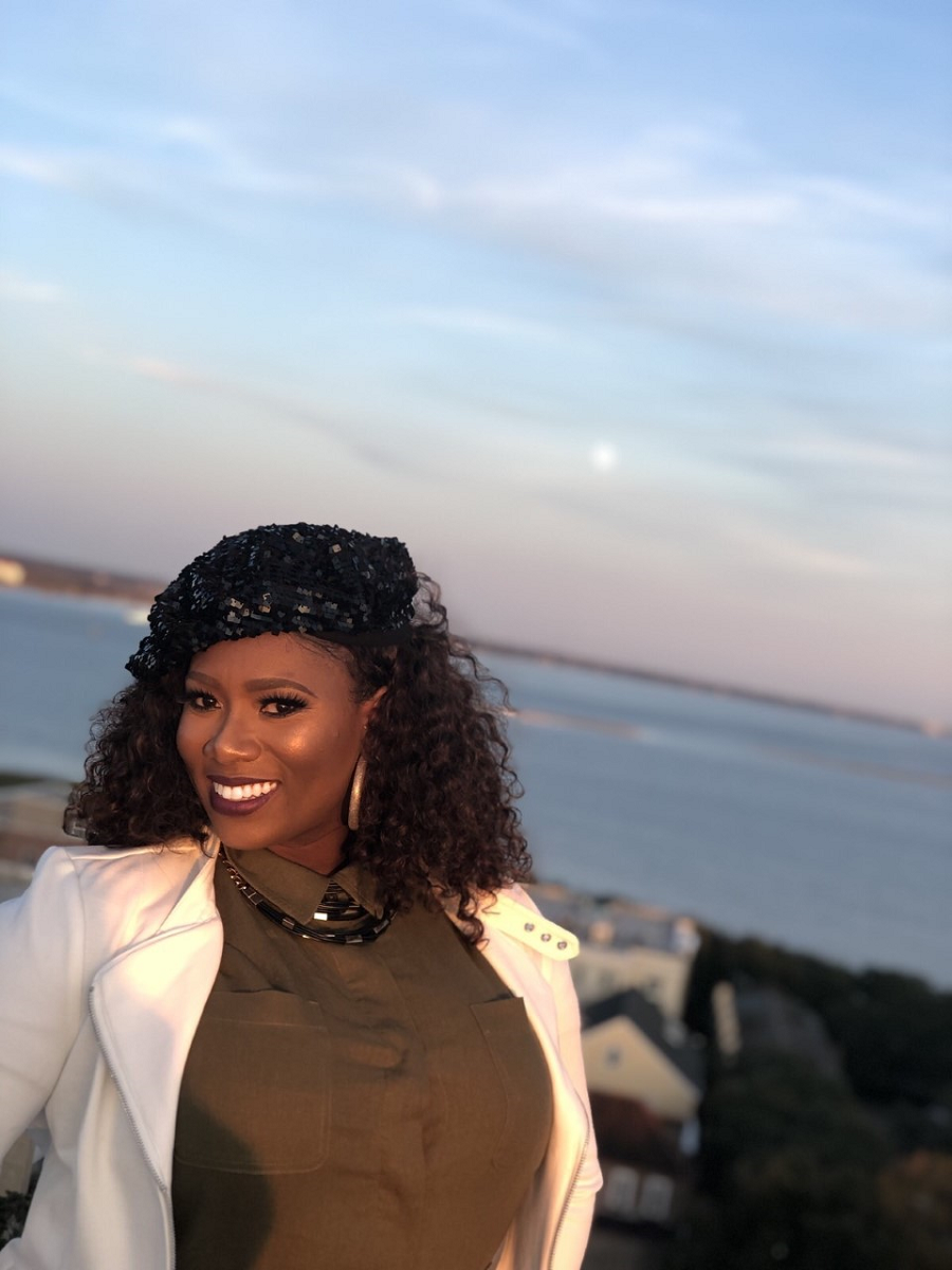 Quiana smiles with the ocean in the background