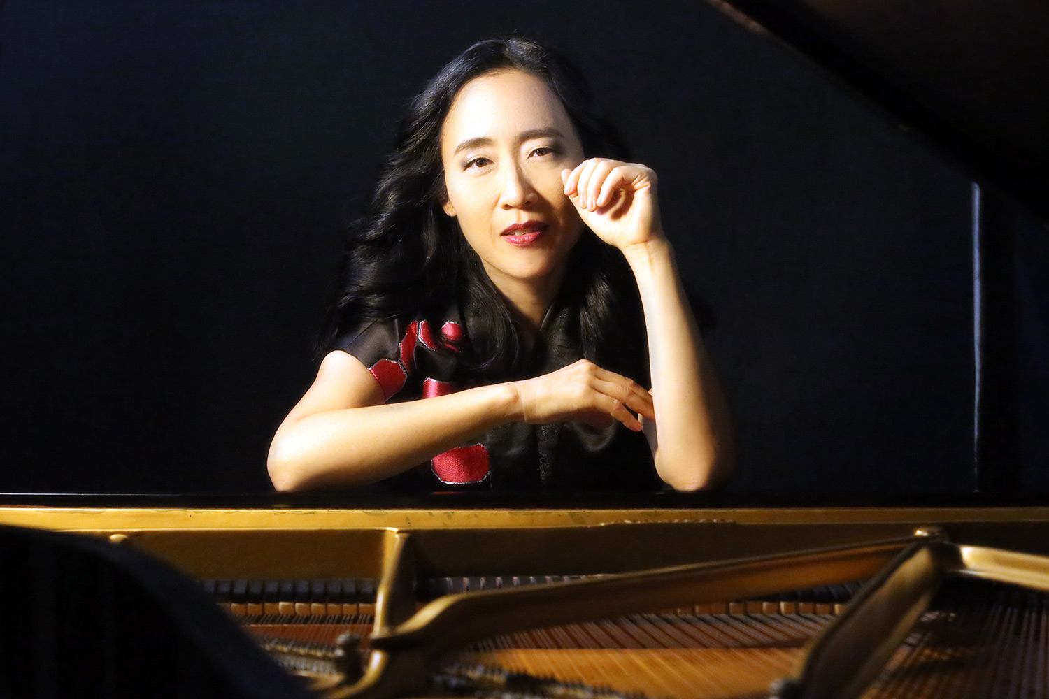 Helen Sung leaning on a piano
